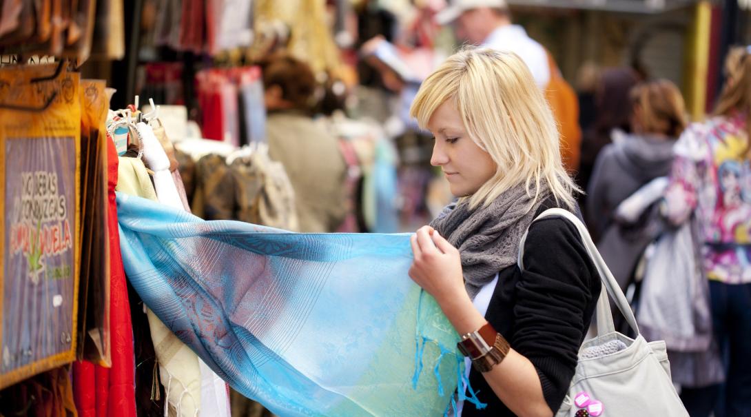 A participant explores a local market as part of her ethical consumerism project abroad. Woman learns about ethical consumerism on a trip abroad.